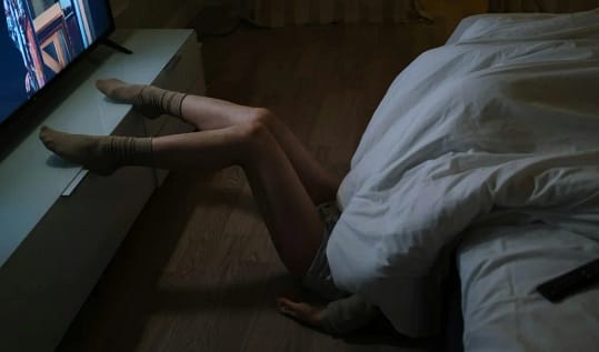 Person watching TV at night showing Poor Sleep Habits