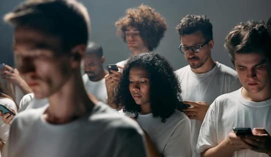 Office worker distracted by smartphone showing productivity loss due to Phone Addiction